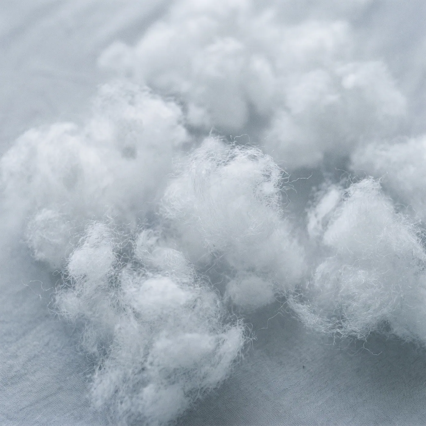 Close-up of fluffy white down-alternative fiber clusters